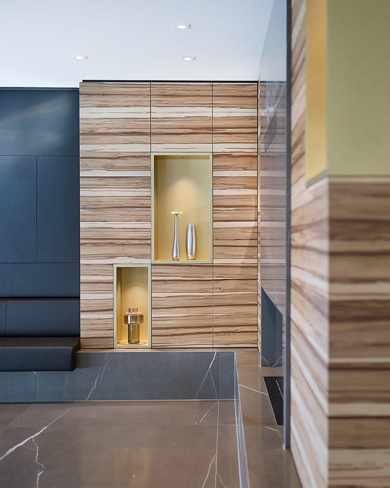 Eine edle Schrankfront aus Holz mit goldenen Elementen und Steinkomponenten.