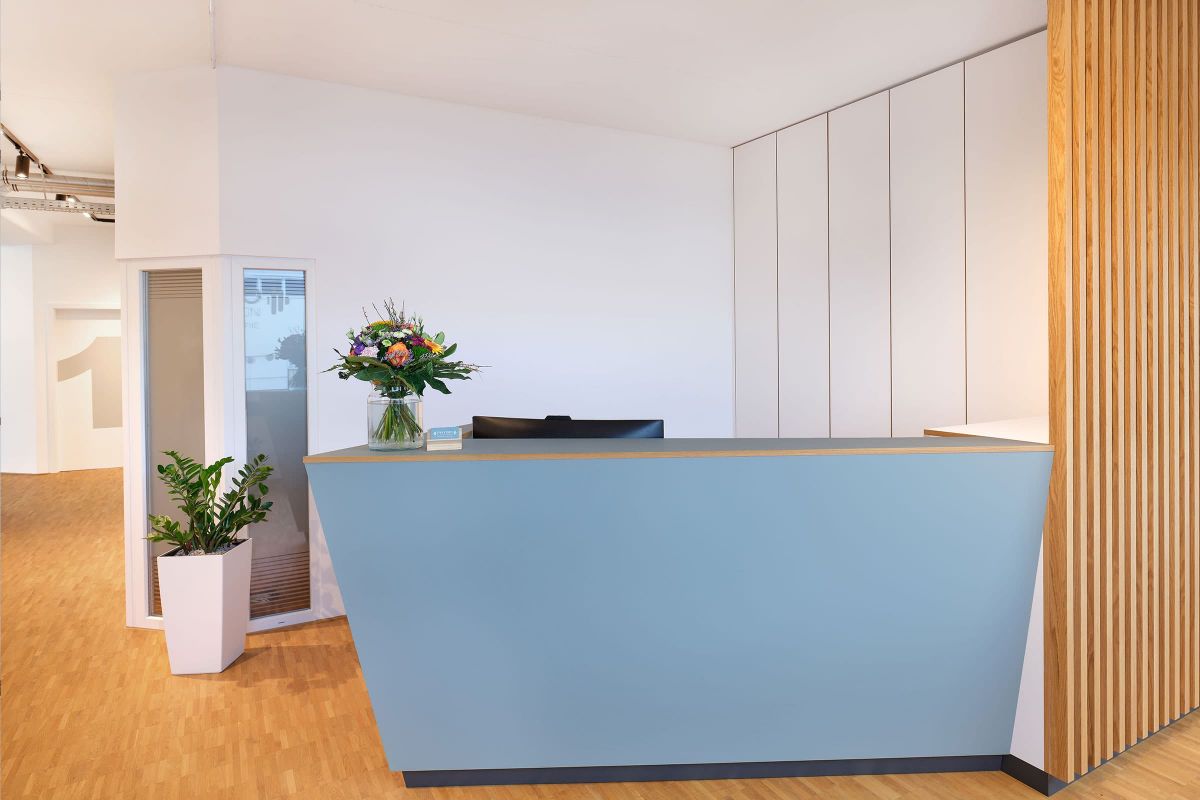 Heller Praxisempfang mit individuell gefertigten Holzmöbeln und Wartebereich von der Echaz Schreinerei