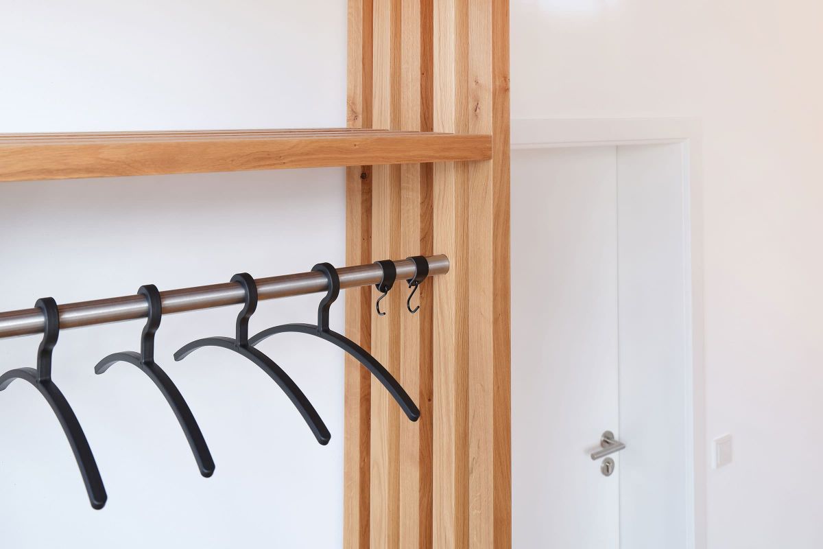 Individuell gefertigte Garderobe aus Holz mit Kleiderstange für eine Praxis, umgesetzt von der Echaz Schreinerei