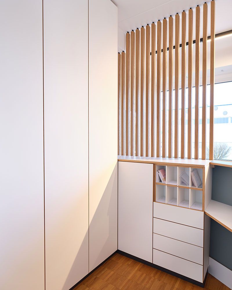 Individuell gefertigter Einbauschrank mit Holzlamellen als Teil der maßgeschneiderten Praxisausstattung der Echaz Schreinerei
