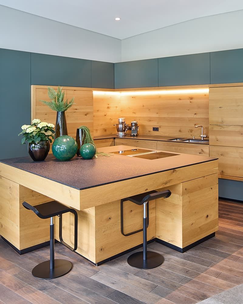 Edle Küche aus Holz mit dunkelgrauen Akzenten und einer Kücheninsel.