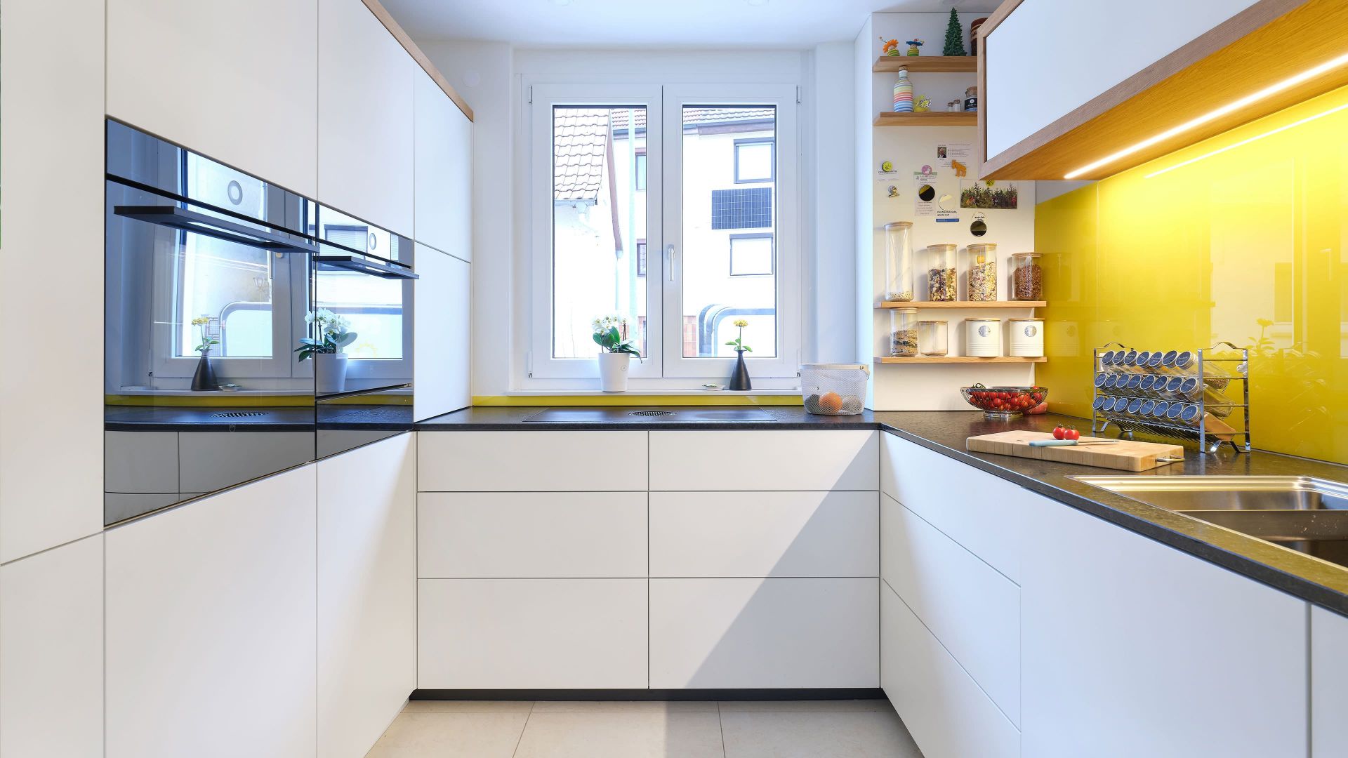 Minimalistische Küche mit maßgefertigtem Sideboard, grifflose Fronten und warmem Eiche-Rahmen