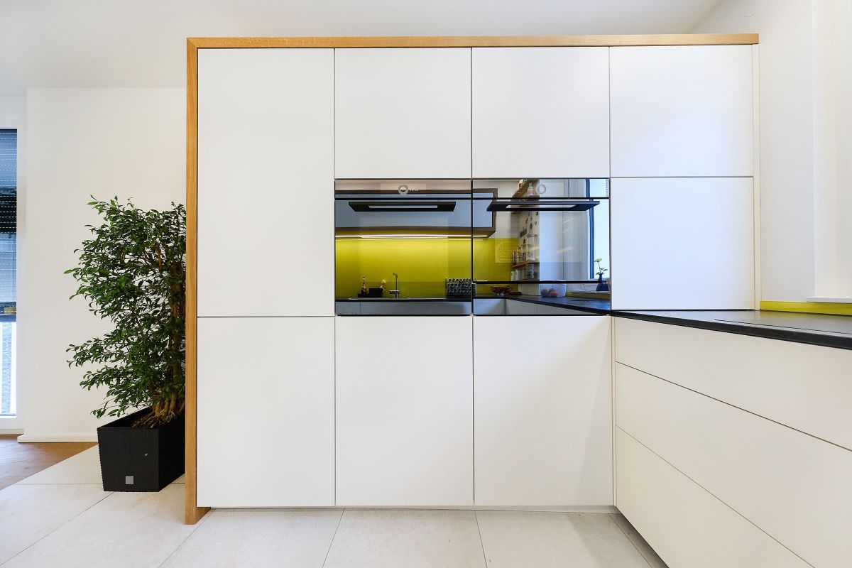 Maßgefertigter Küchenhochschrank mit grifflosem Frontdesign und Eiche-Passepartout