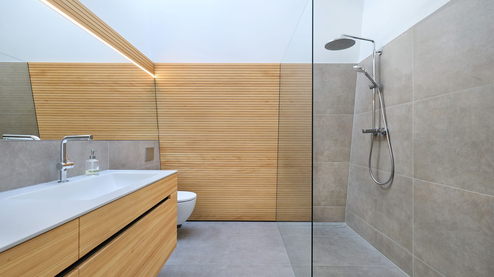 Helles Bad mit Holzdetails, Waschtisch und offener Regendusche.