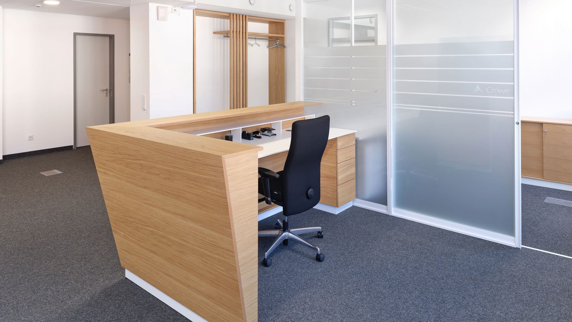 Individuell gefertigter Empfangsarbeitsplatz mit Holzverkleidung und Stauraum von der Echaz Schreinerei