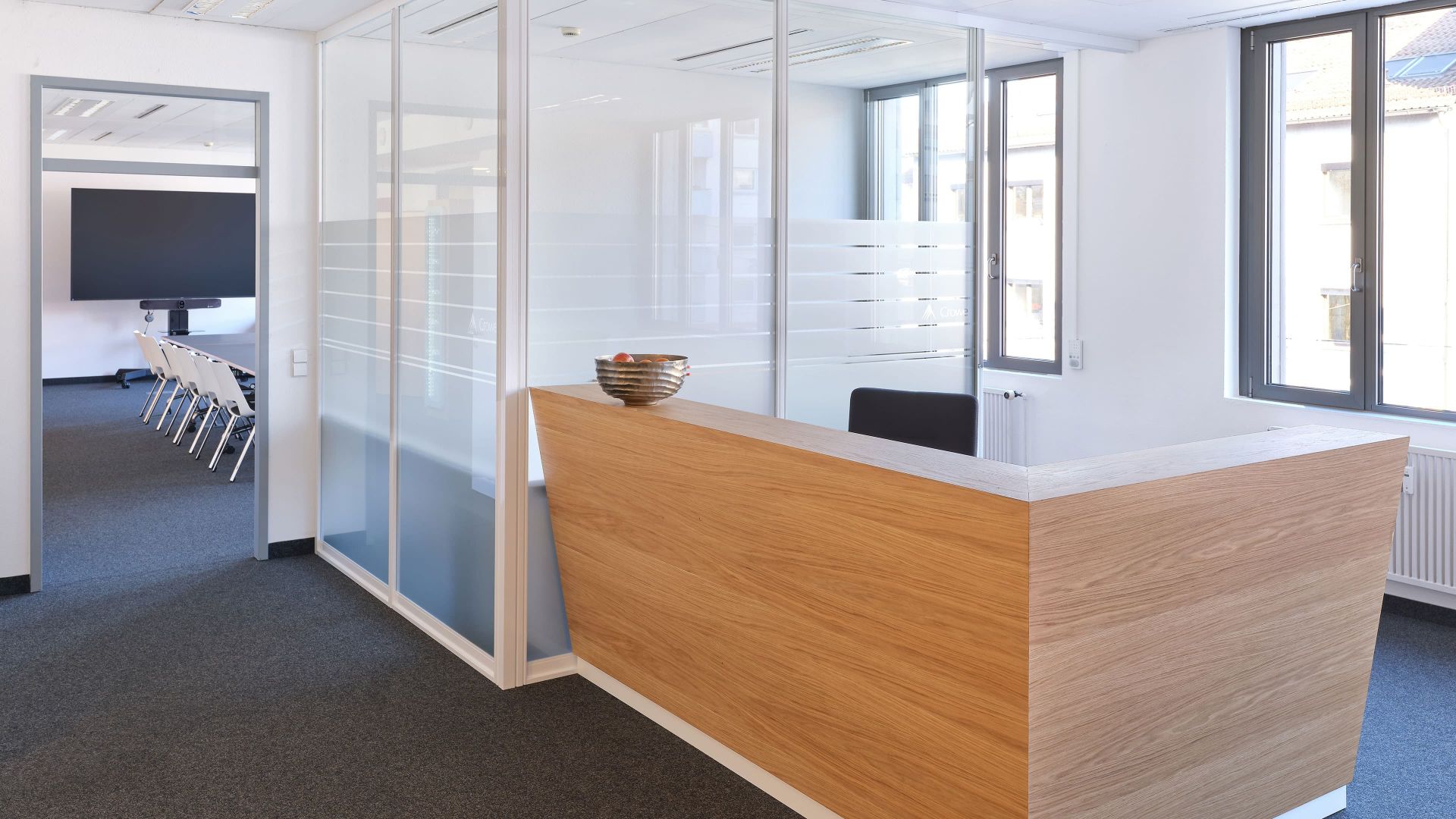 Maßgefertigter Empfangstresen aus Holz in einem modernen Bürogebäude, gefertigt von der Echaz Schreinerei